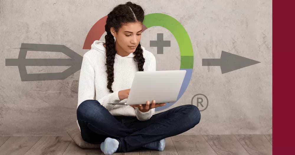 Girl with braids and long dark hair sitting on a cushion. She has her laptop in her hands and is taking the exam preparation course by Swiss Exams "Swiss Exams Academy".