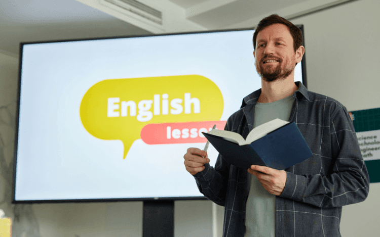 teacher teaching English in front of the board - literature builds advanced language skills, and strong language competence deepens literary understanding.